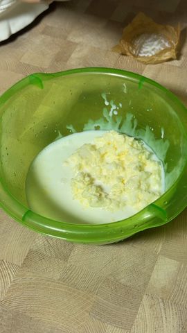 Комки масла в пахте в зелёной миске